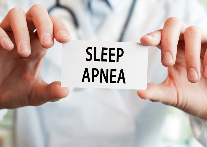 Oral Appliances 5 Doctor holding a sign that reads "SLEEP APNEA," emphasizing the importance of addressing sleep health issues related to dental care.